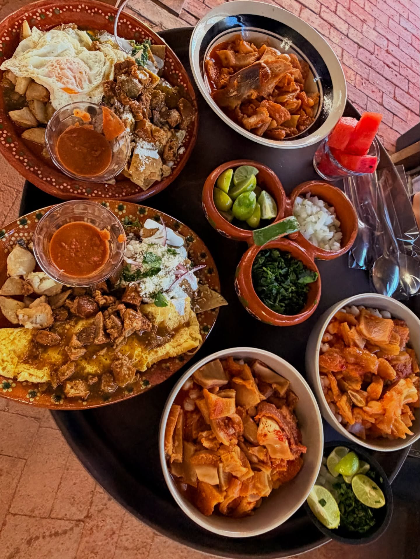 Mesa completa con chilaquiles, menudo y guarniciones